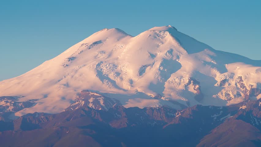 4k, A panoramic view of the snow-capped peaks of Mount Elbrus, the highest point of the European continent, against a clear blue sky, at daytime, Stavropol Krai, Russia