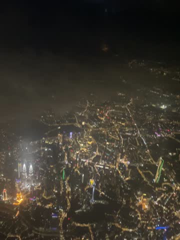 Night view of Kuala Lumpur from above with The Petronas Twin Towers shining bright