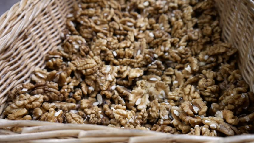 Close-up of many peeled walnuts in a large wicker basket