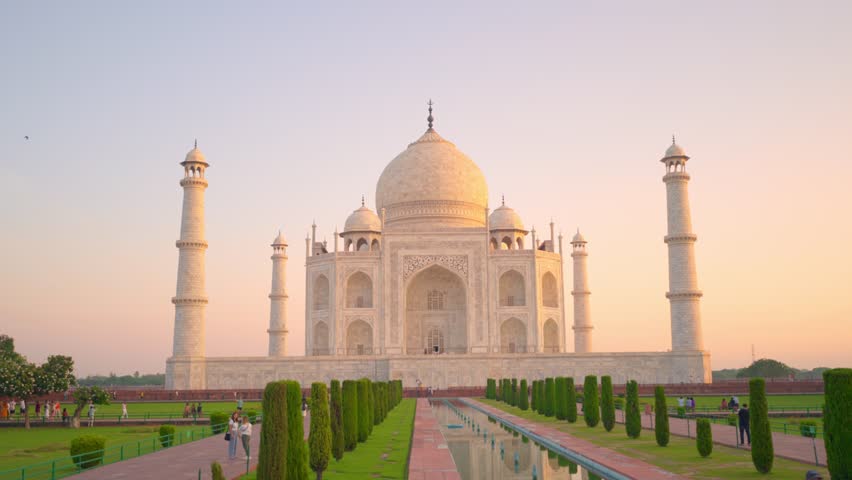 Admire the architectural masterpiece of the Taj Mahal from a breathtaking aerial perspective at sunrise. Explore the intricate details and timeless beauty of this UNESCO site in Agra, India.