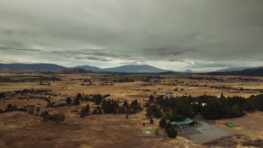 Aerial drone view of California mountains and plains with small settlements