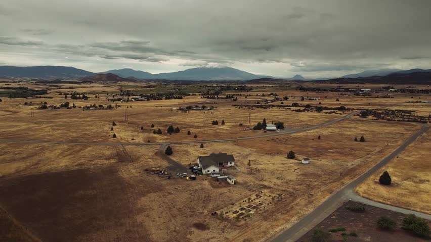 Aerial drone view of California mountains and plains with small settlements