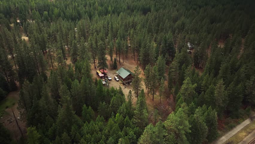 Aerial drone view of small house in the forest and mountains, USA