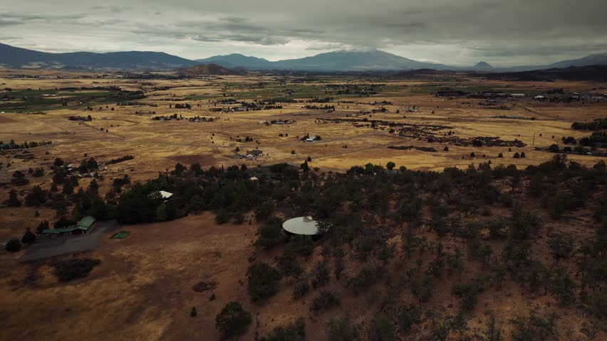 Aerial drone view of California mountains and plains with small settlements