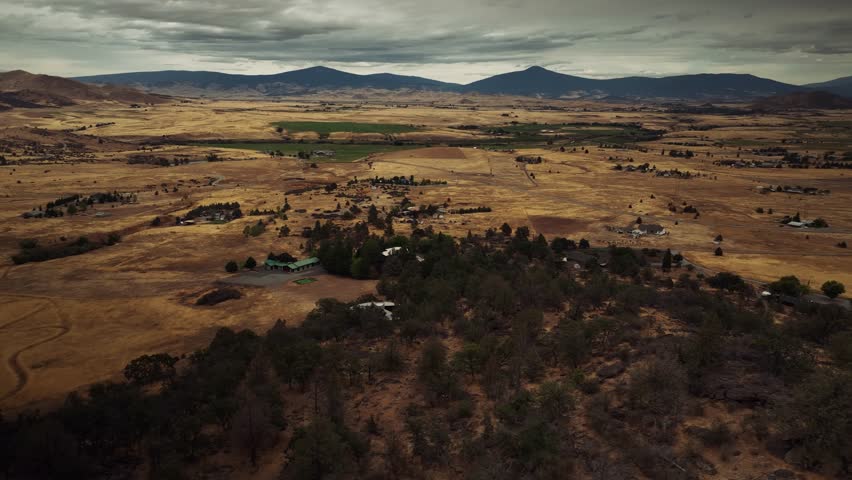 Aerial drone view of California mountains and plains with small settlements