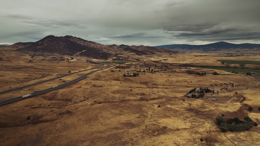 Aerial drone view of California mountains and plains with small settlements