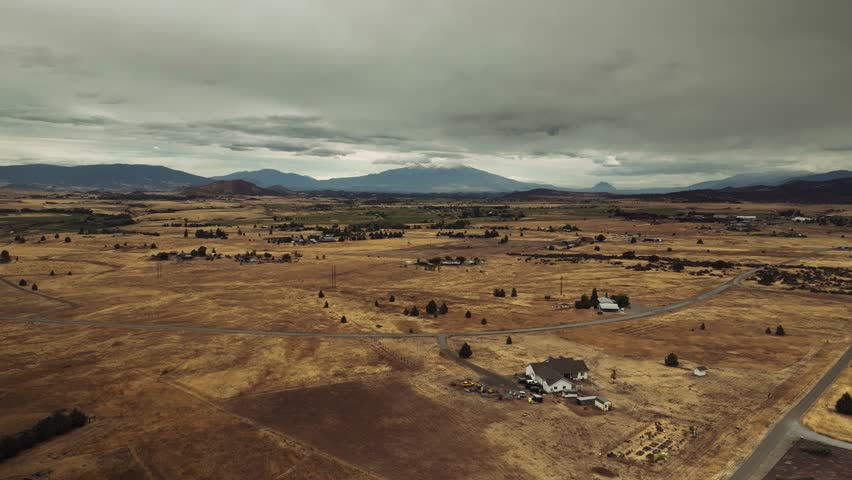 Aerial drone view of California mountains and plains with small settlements