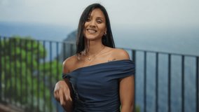 Hispanic woman on a seaside promenade making a victory gesture in a relaxed outdoor beach setting with ocean view. - Powered by Shutterstock - Get 15% off with code: PIKWIZARD15