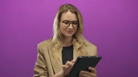 Blonde woman using tablet on pink background, dressed in beige blazer, showcasing technology and modern communication. - Powered by Shutterstock - Get 15% off with code: PIKWIZARD15
