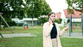 Upset woman talking on the phone while walking in a city park. Woman with phone in hands working remotely and solving problems. Woman heard terrible news on the phone. - Powered by Shutterstock - Get 15% off with code: PIKWIZARD15