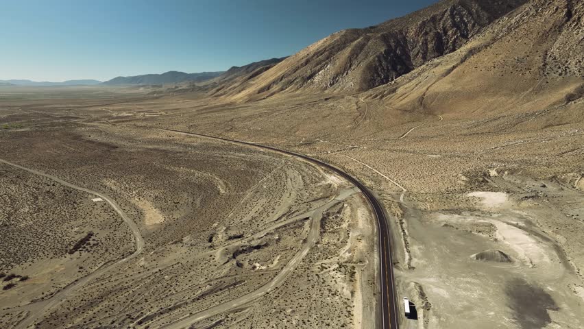 Aerial drone view of Owens Lake and desert mountains with highway, California USA