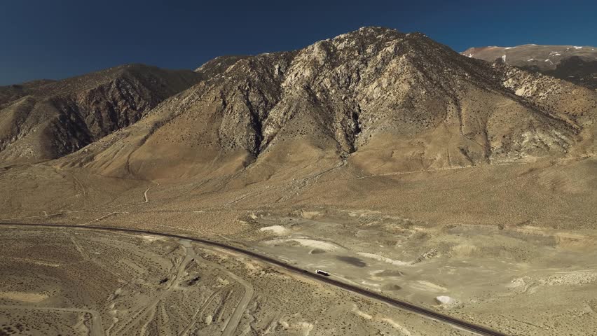 Aerial drone view of Owens Lake and desert mountains with highway, California USA