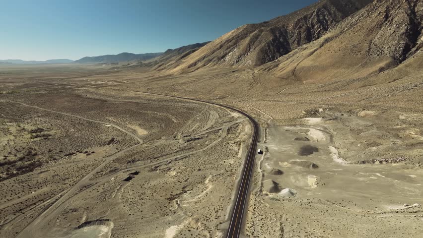 Aerial drone view of Owens Lake and desert mountains with highway, California USA