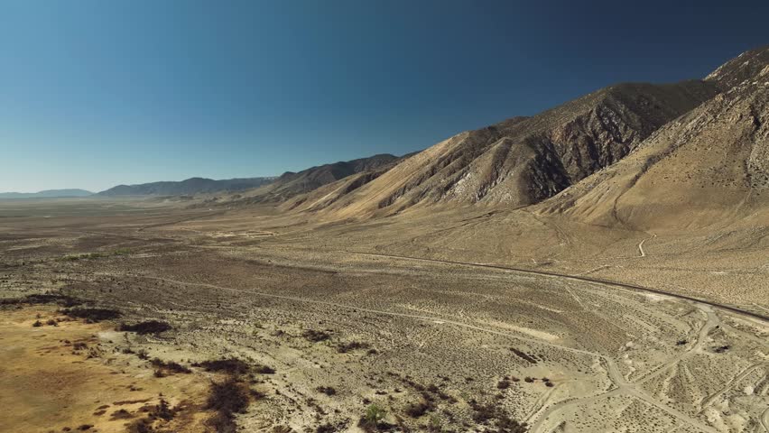 Aerial drone view of Owens Lake and desert mountains with highway, California USA