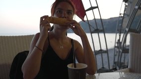 Woman eating corn on the cob at beachside cafe during sunset, enjoying summer evening - Powered by Shutterstock - Get 15% off with code: PIKWIZARD15