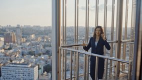 Happy manager speaking cellphone standing at office balcony. Smiling businesswoman talking smartphone looking cityscape. Positive woman employee enjoy friendly mobile phone conversation at break. - Powered by Shutterstock - Get 15% off with code: PIKWIZARD15