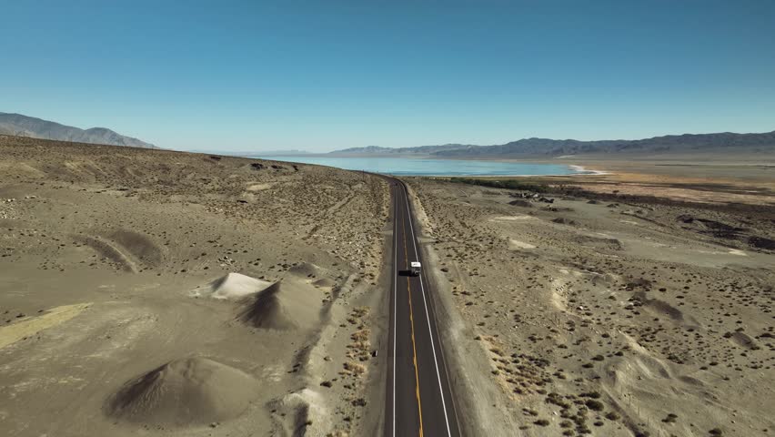 Aerial drone view of Owens Lake and desert mountains with highway, California USA