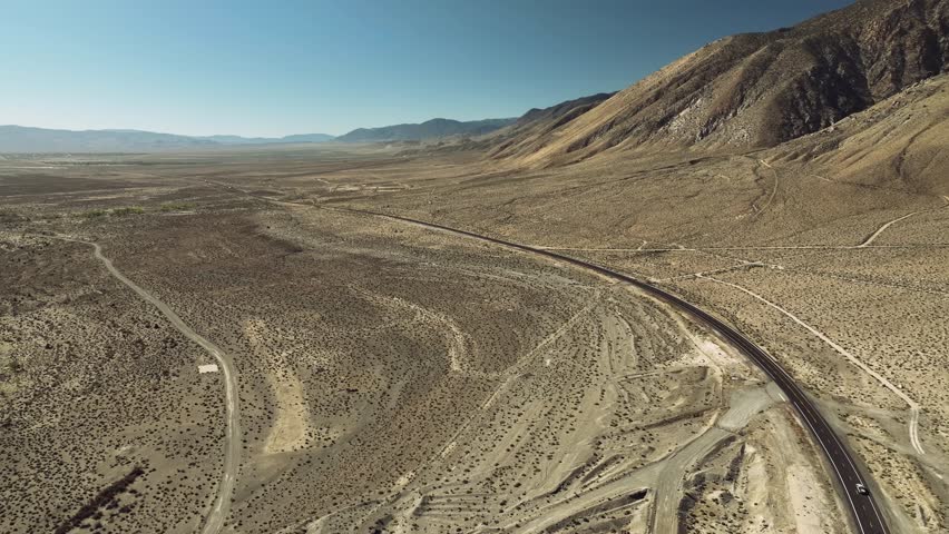 Aerial drone view of Owens Lake and desert mountains with highway, California USA