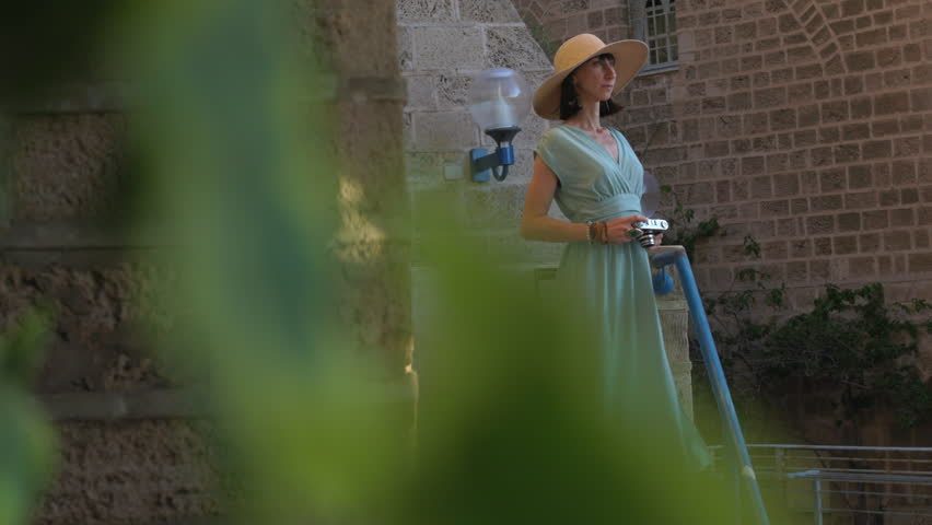 Young pretty tourist taking pictures in the city, photographer taking photos, urban concept, cheerful beautiful woman with camera walking around the city. Jaffa. Israel.