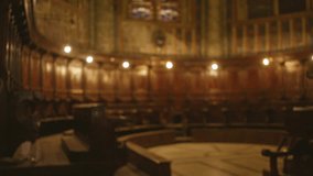 Blurred view of a historic church interior showcasing ornate wooden benches and dim lighting reflecting a serene religious atmosphere with blurred stained glass details. - Powered by Shutterstock - Get 15% off with code: PIKWIZARD15