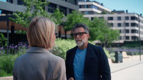 Angry businesswoman and smiling businessman outdoors in business district. Woman frustrated, man indifferent, tense dispute in professional urban environment - Powered by Shutterstock - Get 15% off with code: PIKWIZARD15