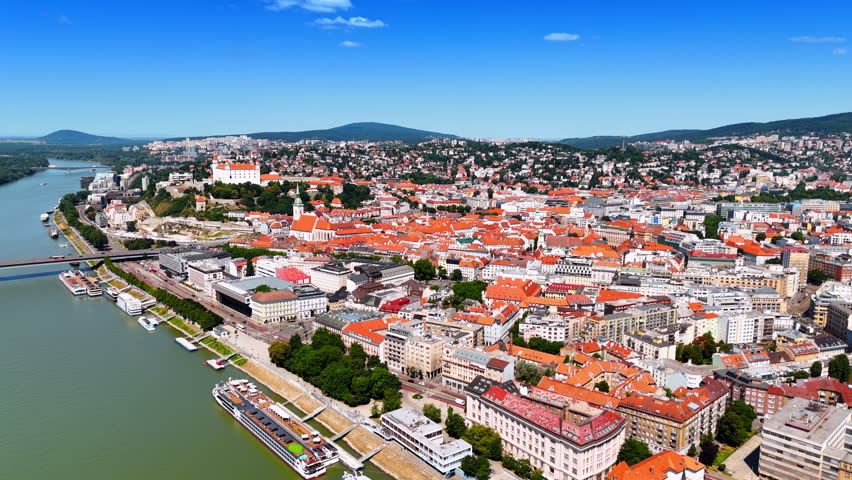 Approaching a beautiful riverside of the Danube with historical buildings. Aerial perspective on the old town of Bratislava, Slovakia.