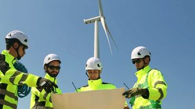 Team engineers in tight suits carrying blueprints and tool boxes walk into the wind turbine power station area working as a team to inspect maintenance schedule.
 - Powered by Shutterstock - Get 15% off with code: PIKWIZARD15