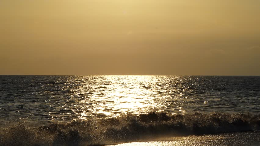 Beautiful infinite sea in the rays sunset touches the horizon