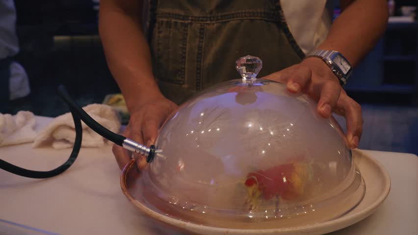 cinematic 4k video chef lifting glass cloche to reveal smoky sushi platter on asian kitchen counter shot 2