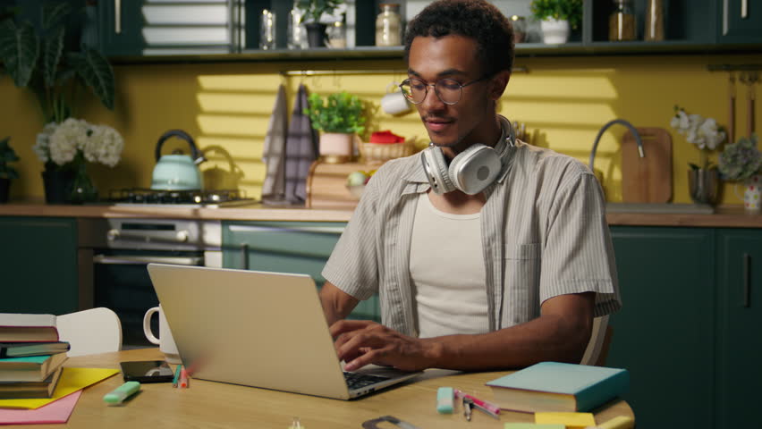 African American business man guy ethnic male freelancer student teen gamer typing laptop internet browsing working online shopping computer studying at home kitchen thumb up recommend food delivery