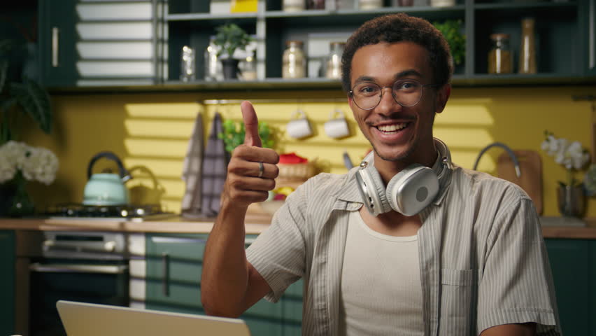 African American business man guy ethnic male freelancer student teen gamer typing laptop internet browsing working online shopping computer studying at home kitchen thumb up recommend food delivery
