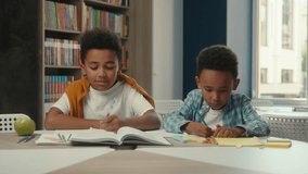African American little boys kids children siblings pupils studying in school help classmate learning together prepare lesson homework task study together two schoolboys students friends support smile - Powered by Shutterstock - Get 15% off with code: PIKWIZARD15