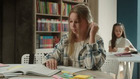 Bored sad frustrated teen kid Caucasian girl pupil schoolgirl upset learner at desk tired lazy exhausted student child studying lesson reading boring book learning in classroom school study textbook - Powered by Shutterstock - Get 15% off with code: PIKWIZARD15