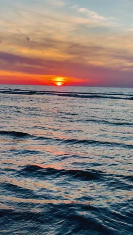 Beautiful sunset over the North sea, flying birds , rocks, scenic clouds. Ostend, Belgium. 