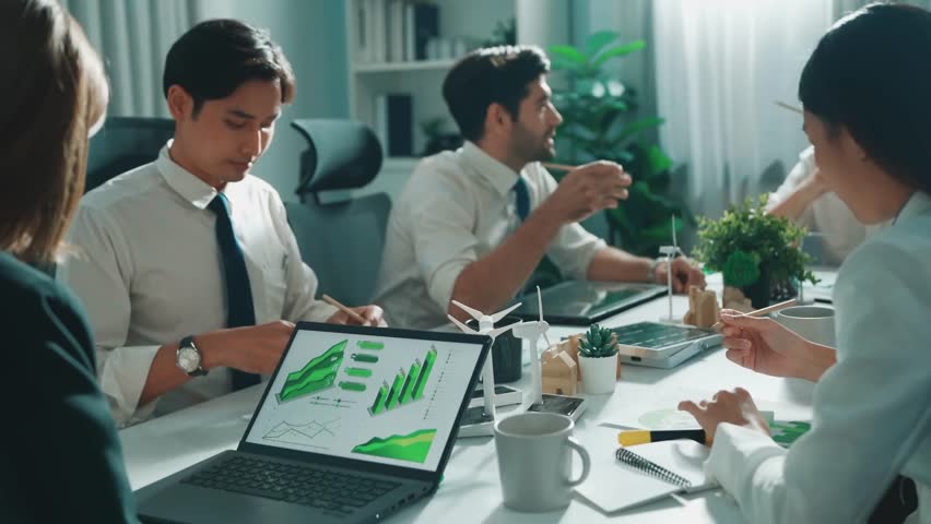 Professional smart business team discussing about using clean energy and sustainable investment at meeting table with wind mill, document with environmental graph and wooden house model. Alimentation.