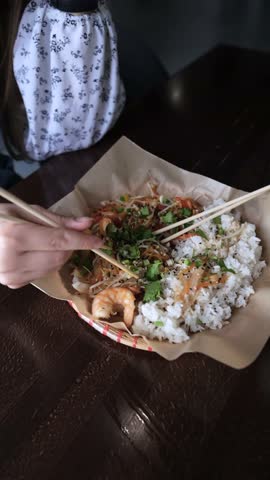 Close-up of Caucasian woman eating pan-Asian cuisine