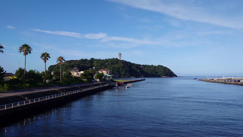 sea ​​and island.Waves crashing on the sandy beach with Dejima in the background.Enoshima is the most famous beach in Japan.江ノ島