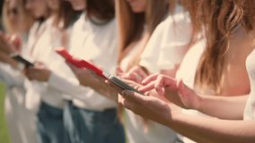 A group of business individuals enjoys a summer day in the park while utilizing their smartphones for networking and collaboration, sharing ideas and information in a vibrant atmosphere. - Powered by Shutterstock - Get 15% off with code: PIKWIZARD15