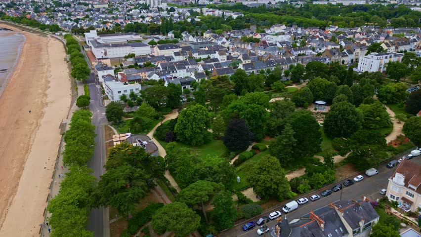 Panning tilted drone movement over the Botanical Garden with new kiosk surrounded by beach and houses, Saint-Nazaire, Loire-Atlantique, France.