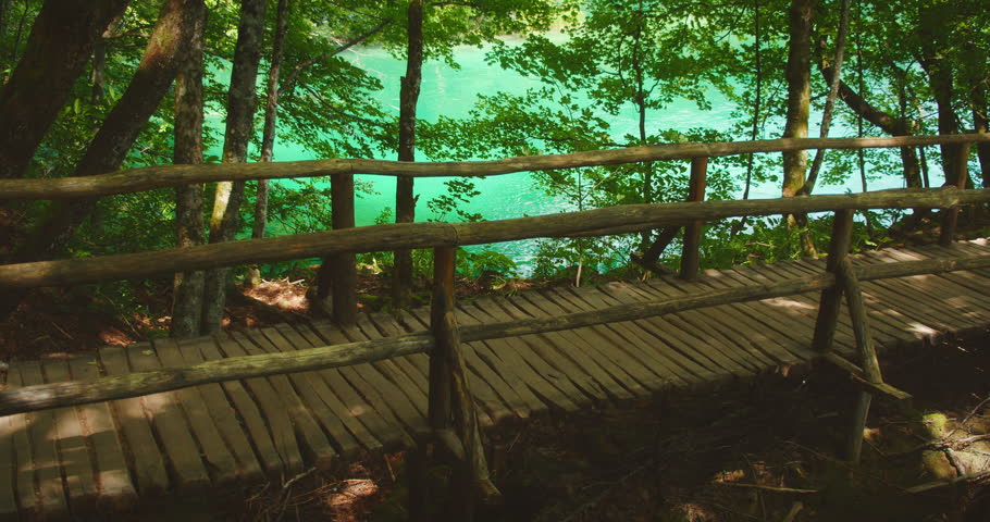 Woman tourist records a video on a forest hiking trail by the lake in Plitvice Park