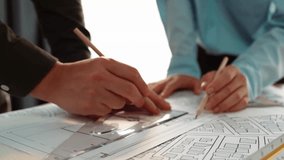 Smart architect and safety engineer discussion about building blueprint on table with architectural document, measurement tools and wooden block scatter around at modern office. Closeup. Delineation. - Powered by Shutterstock - Get 15% off with code: PIKWIZARD15