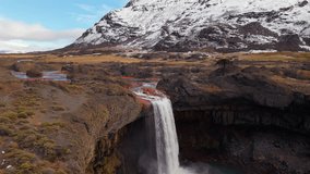 Aerial view of El Salto del Agrio waterfall in Caviahue, Neuquén, Argentina, with snowy andean mountains in background - Powered by Shutterstock - Get 15% off with code: PIKWIZARD15