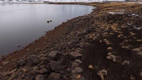 Aerial over the shoreline of Lake Caviahue, Neuquen, Patagonia, snow capped slopes and volcanic terrain tied to geotourism in Caviahue Copahue, forward drone flyover. - Powered by Shutterstock - Get 15% off with code: PIKWIZARD15