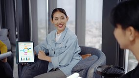In a modern office, Asian businesswoman presents data summary charts on a tablet to her colleagues, financial report analysis teamwork strategy planning corporate success, marketing, data analytics - Powered by Shutterstock - Get 15% off with code: PIKWIZARD15