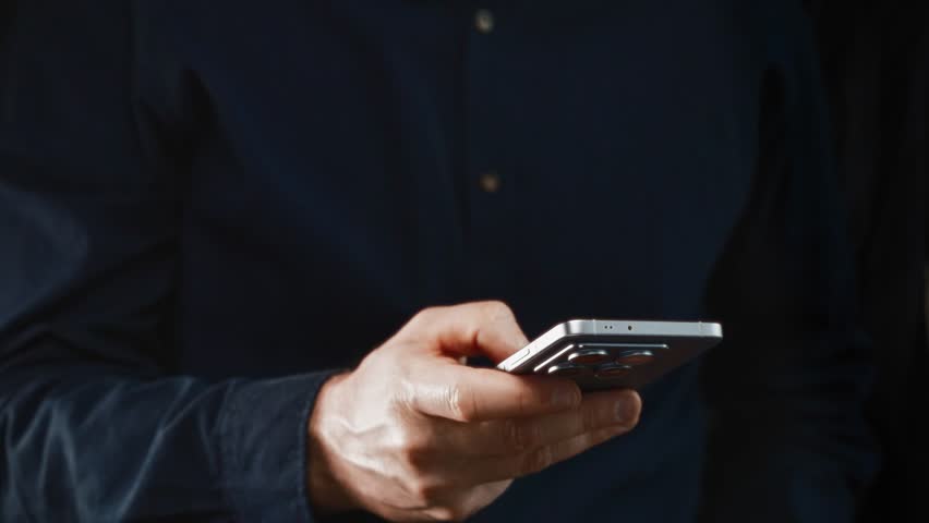 Close-up of male hand holding modern smartphone for online banking and crypto payments. Showcases mobile financial apps and digital transaction convenience. - Powered by Shutterstock - Get 15% off with code: PIKWIZARD15