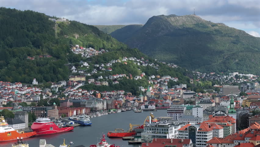 Aerial footage of Bergen city center with the iconic Bryggen waterfront and surrounding mountains
