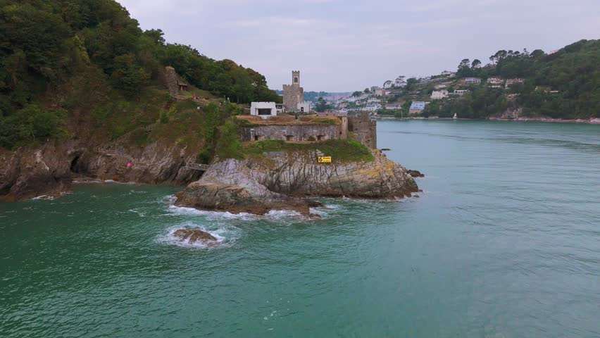 Daytime, aerial ascent over Dartmouth Castle with vista of Dartmouth Town, estuary and Naval college.
