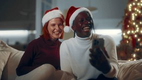 Online video call in Christmas, black man and Caucasian girlfriend celebrating. Happy diverse people spending Xmas eve at home, congratulating family and friends remotely, heart is symbol of love - Powered by Shutterstock - Get 15% off with code: PIKWIZARD15