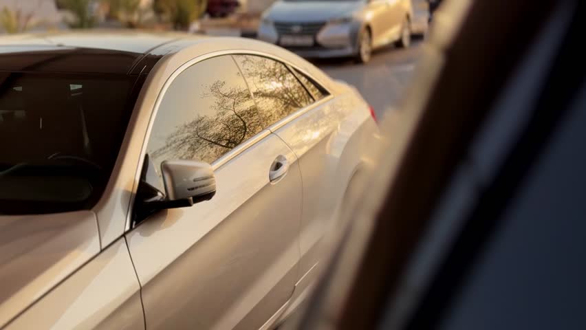 Cinematic 4K close-up of a sleek luxury car with golden-hour reflections on tinted windows. Perfect for auto ads, lifestyle visuals, travel, and transportation projects.