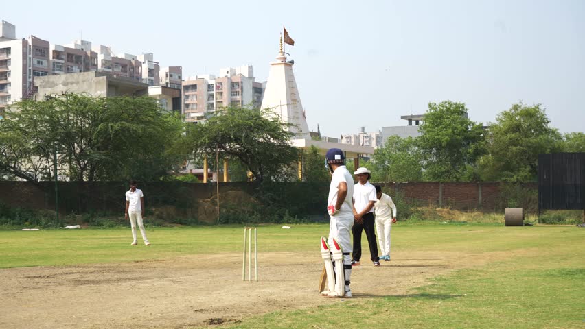Young men playing cricket on the field, During Youth Cricket Match